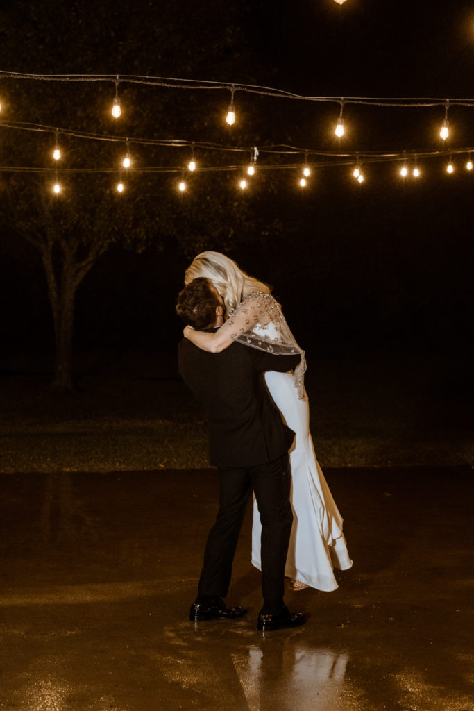 Groom lifting bride up first dance