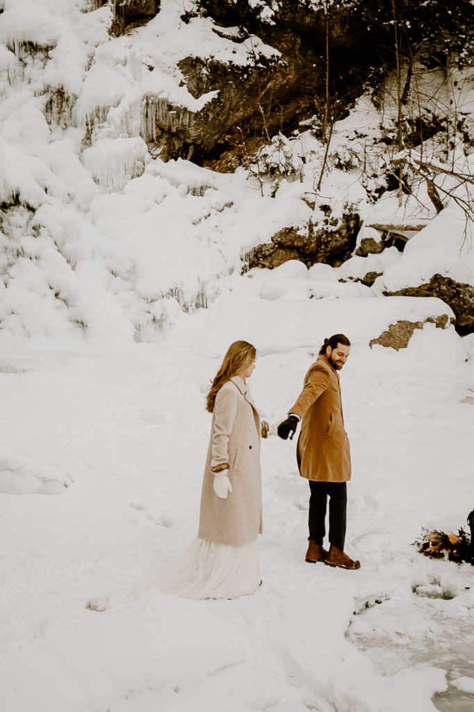 bride and groom walking on snow