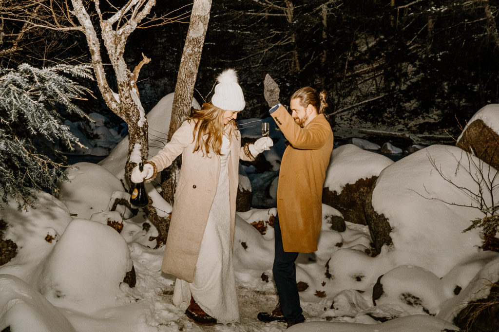 couple dancing in the snow with champagne 