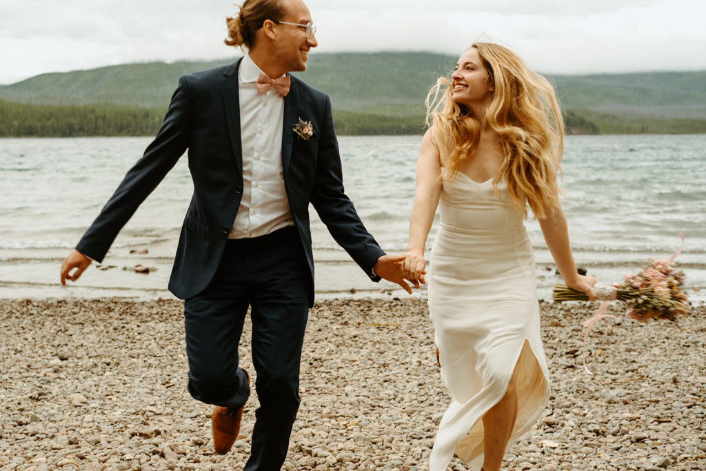 Bride and Groom running in Glacier National Park