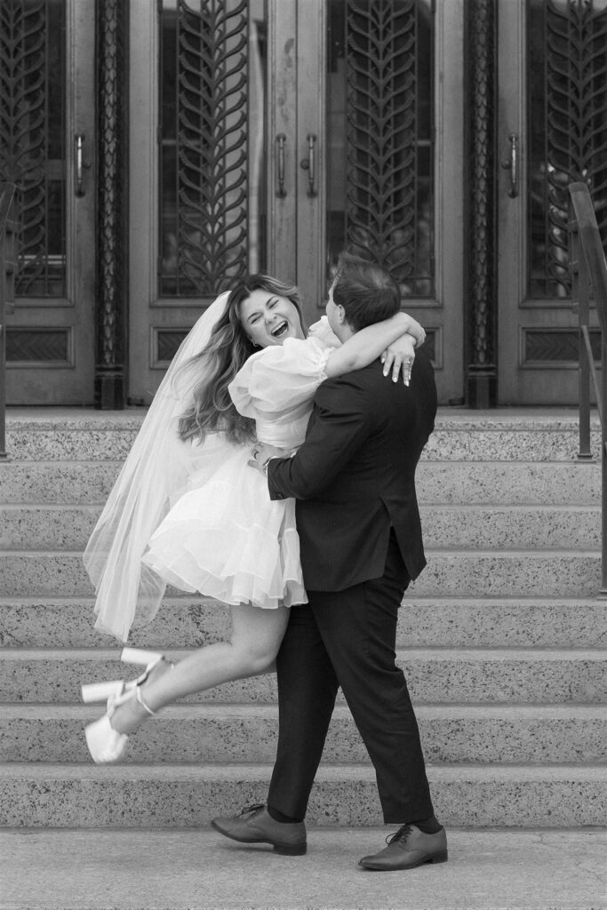Groom lifting Bride and twirling her around courthouse steps