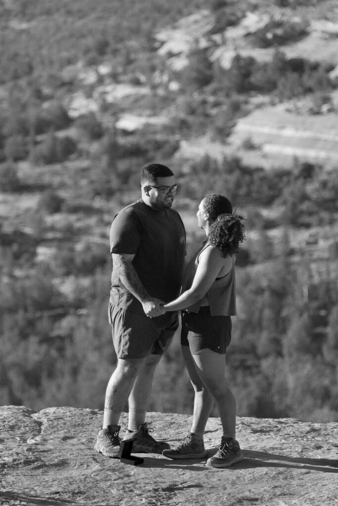An intimate black-and-white moment captured post-proposal at Sedona’s Devil’s Bridge, as the couple shares a joyful gaze, celebrating their new engagement.