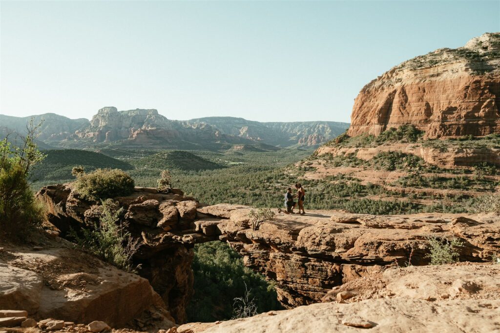 Sedona Devil's Bridge proposal captured at sunset with a breathtaking view of red rock landscapes, as a couple shares an unforgettable moment on the iconic sandstone arch.