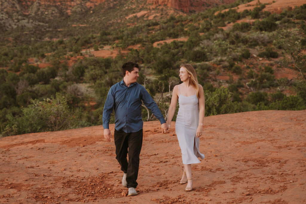 Man and women holding hands walking in the desert