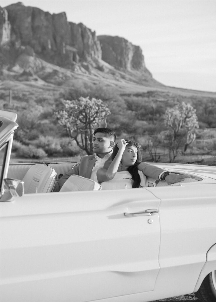 man and woman in vintage car in the desert looking opposite directions