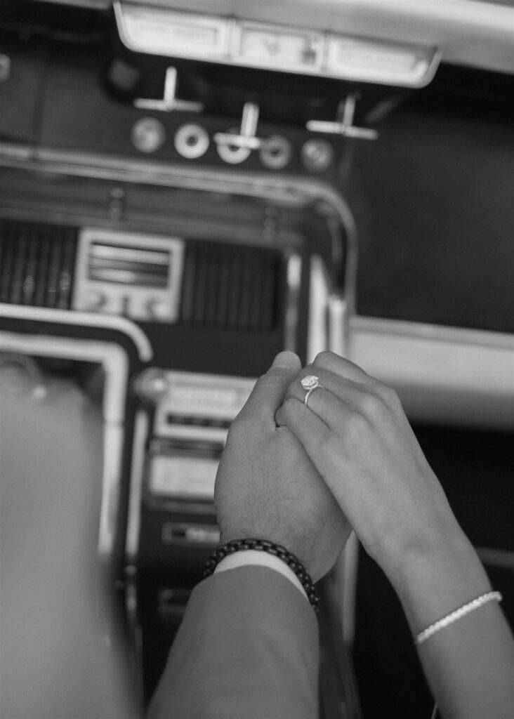 Man and women holding hands showing off engagement ring