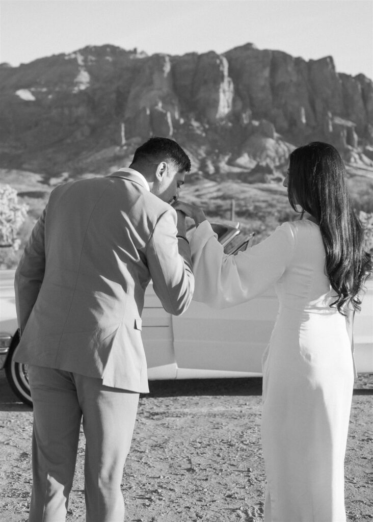 Man kissing woman's hand in the desert
