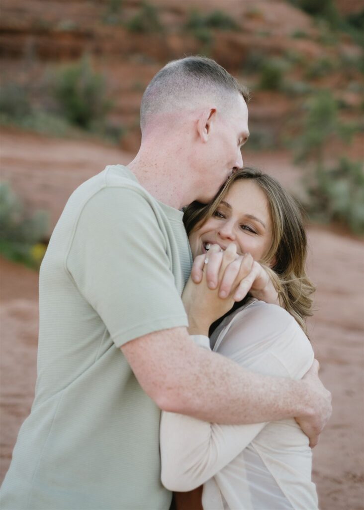 Cathedral Rock engagement photos in Sedona featuring a couple hiking and posing on red rock cliffs at sunset